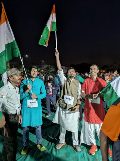 A group of friends and fellow runners celebrate with flags before the start of the race.