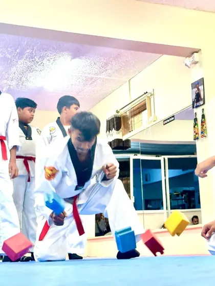 A student sends the blocks flying with a powerful strike.