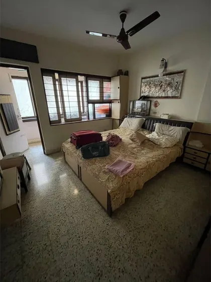**BEFORE:** A guest bedroom with dated furniture and a small window, resulting in a dark and cramped environment.