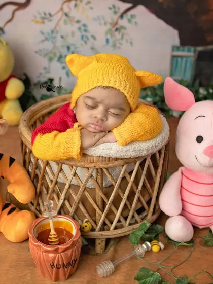 A tiny Winnie the Pooh curled up in a basket, dreaming of honey. I carefully pose newborns to ensure they are always comfortable and secure, allowing for these adorable themed shots.