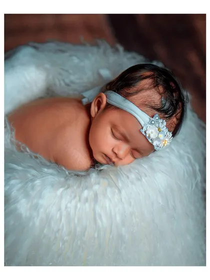 A close-up portrait of the newborn in the bucket prop.