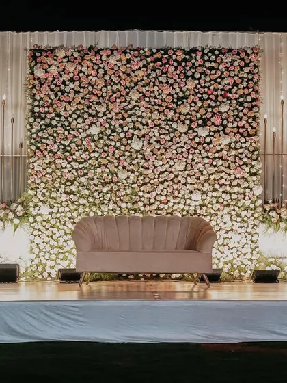 The engagement stage, featuring a plush sofa set against a massive wall of ombre-style pink and white flowers.