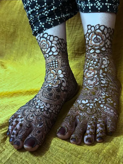 This photo captures the full view of the intricate bridal foot mehendi, showing how the design covers the toes, foot, and ankle.
