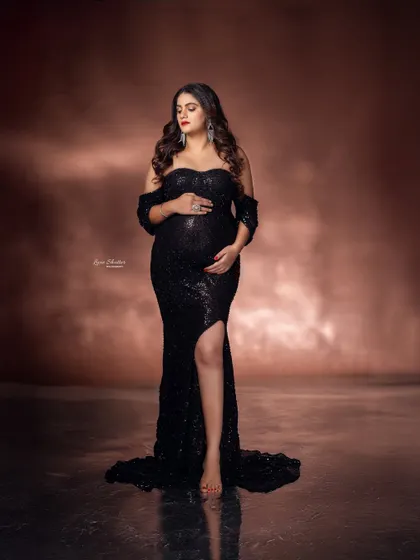 A quiet, contemplative moment. The way the light falls on the mother-to-be, highlighting her bump and the texture of the sequin gown, is simply stunning.