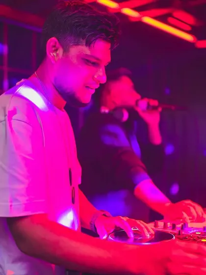 Here you can see me mixing on the decks while my partner hypes the crowd on the microphone. We work in tandem to control the party's energy.