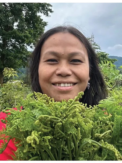 Gitika, who inherited the Fiddlehead Fern Pork recipe, holding a fresh bunch of ferns.