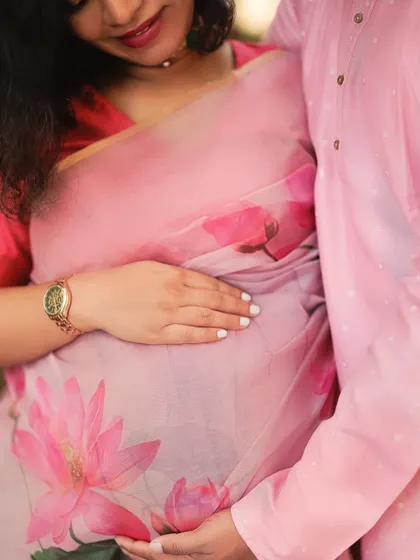 A close-up detail shot focusing on their hands cradling the baby bump. This image symbolizes their shared journey of love and the new life they have created together.
