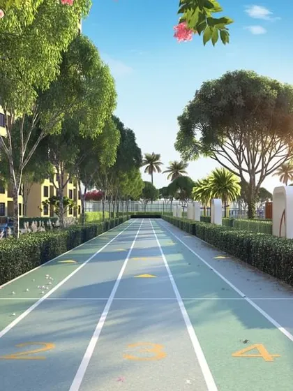 A dedicated running track lined with formal hedges and trees, designed for fitness enthusiasts within a large residential community.