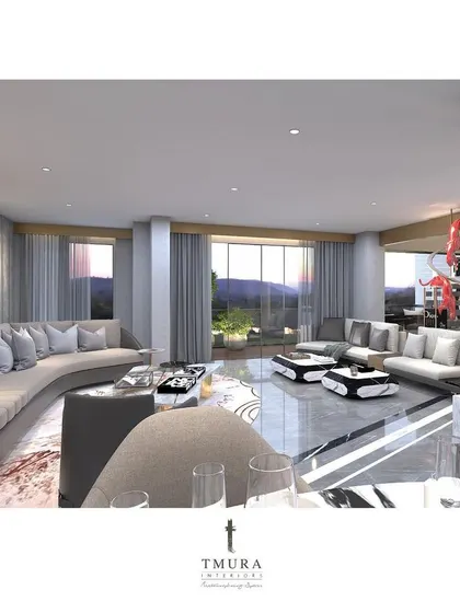 This expansive living room is designed for large gatherings, featuring multiple seating areas with custom curved sofas. A life-sized sculpture and a large mosaic artwork act as focal points, demonstrating how we integrate art into our interior architecture.