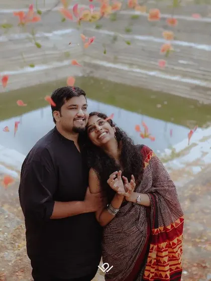 A romantic pre-wedding photo at a beautiful stepwell, with flower petals falling around the couple.