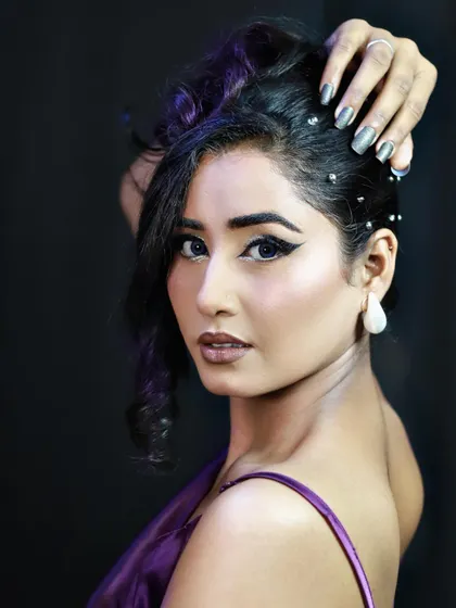 A profile view highlighting the textured updo and the sharp, clean lines of the winged eyeliner.