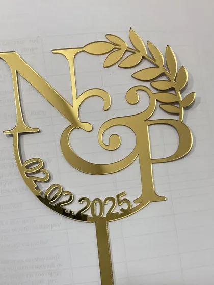 A custom wedding monogram topper in gold mirror acrylic. We can create these with your initials and wedding date for a beautiful, personalized keepsake.