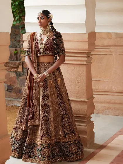 For this heritage look, I styled a bride in a rich, multi-textured velvet lehenga. The intricate zardozi work and traditional braid hairstyle, adorned with flowers, evoke a sense of old-world charm and grandeur.