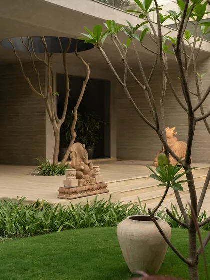 The integration of nature is a key theme, seen in the voids cut for trees and the placement of art and sculpture in the garden. The architecture frames and celebrates the natural environment.