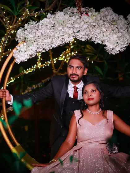 A glamorous night-time shot. The groom's dark suit with a red tie subtly picks up the tones in her dress, an example of the small details I focus on in couples styling.