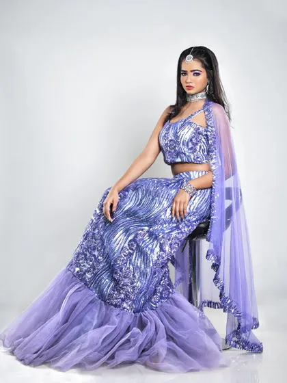 A seated portrait in the lavender lehenga. The makeup features a subtle shimmer on the eyes and glowing skin, ideal for evening events and photoshoots.