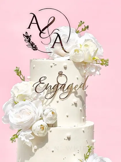 This floating engagement topper with custom initials is a modern and elegant choice. Paired with an "Engaged" cake charm, it creates a stunning look on this tiered cake.