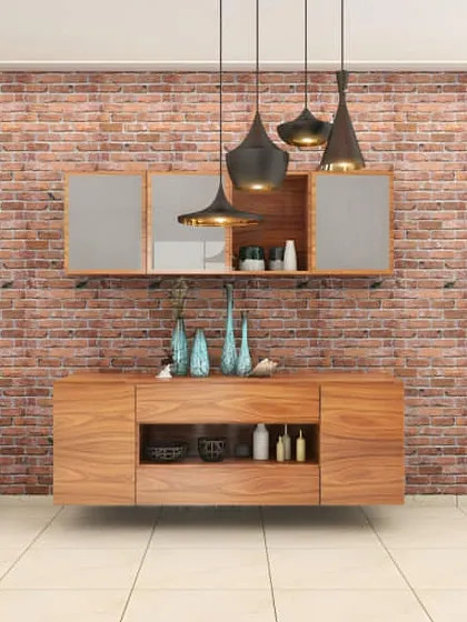 A rustic-industrial crockery unit with a wooden console and a wall-mounted cabinet. The exposed brick wall and modern pendant lights create a stylish dining area backdrop.