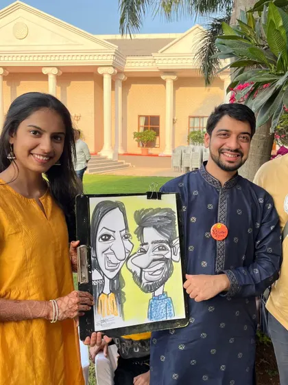 A couple with their caricature at an outdoor wedding event in Ambegaon, Pune.
