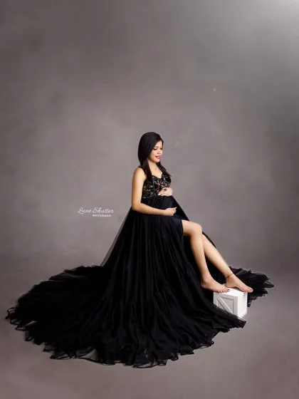 A beautiful seated portrait in a flowing black gown. The delicate lace top adds a touch of romance to the dramatic look.