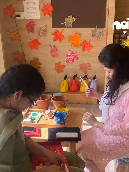 Educators work on crafts during a workshop, surrounded by colorful leaf art. This reflects our emphasis on creating an aesthetically pleasing and inspiring environment that stimulates creativity for both teachers and students.