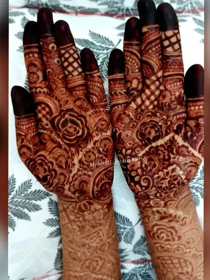 A close-up of the palms, showing the detailed work that goes into every bridal henna. Notice the delicate netting on the fingers and the central floral mandala.