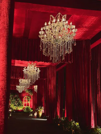The grand entrance corridor, where guests are greeted by a breathtaking line of crystal chandeliers. The perspective shot emphasizes the depth and scale of the decor.