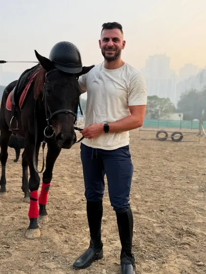 A rider holds the reins of his horse, ready for a lesson. Our horses are equipped with quality tack for safety and comfort.