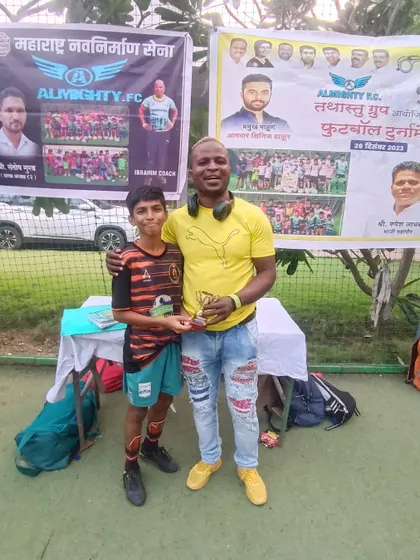 A proud TFA player receiving his award at the Almighty FC tournament.