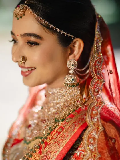 Another lovely shot of the bride, showcasing her beautiful smile and elegant attire. The red veil adds a touch of tradition to her modern look.