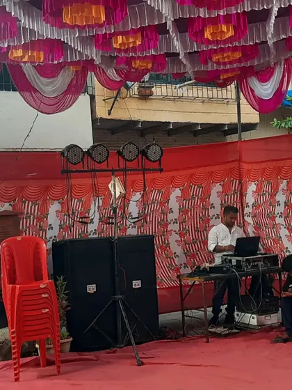 My DJ setup with speakers and lights under a colorful pandal. I provide a complete entertainment package for your event.