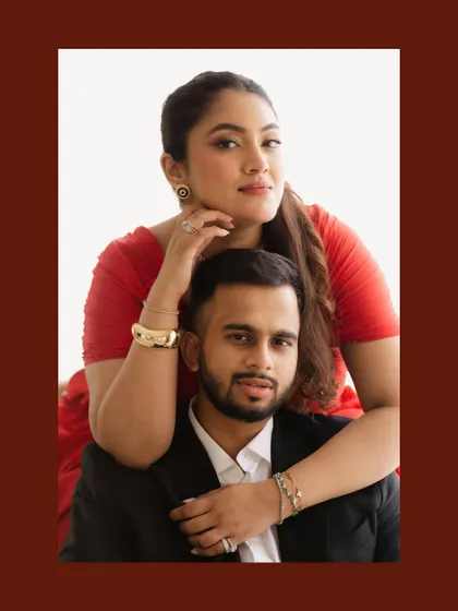 A bold and stylish indoor portrait. The bride's striking red dress and the couple's confident pose create a modern and effortlessly elegant image, showcasing a different side of their personality.