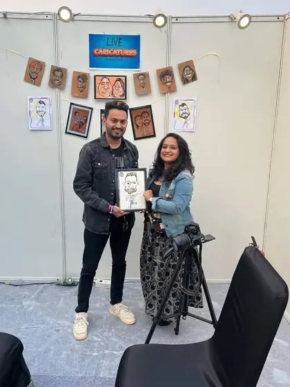 Posing with a gamer and his framed caricature at my booth during the Redbull esports event.