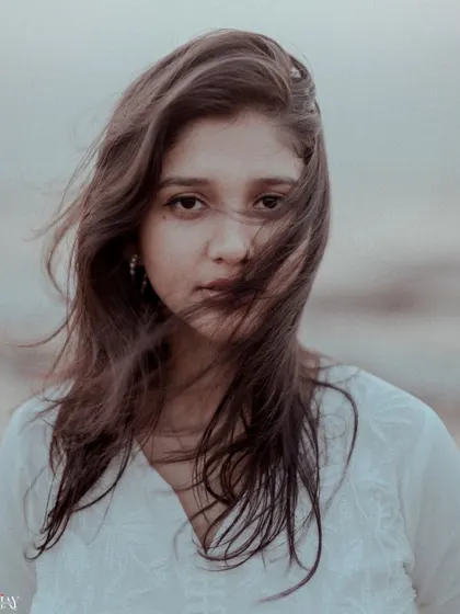 A stunning close-up portrait of the bride-to-be, with the wind creating a beautiful, natural effect.