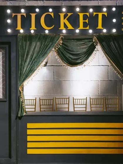 A vintage-style "Ticket" booth for the Bollywood-themed sangeet, making guests feel like they are entering a movie premiere.