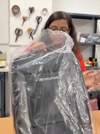 Our team member quality-checking a branded Hyundai backpack before it goes into an onboarding kit. Every item is inspected to meet our high standards.