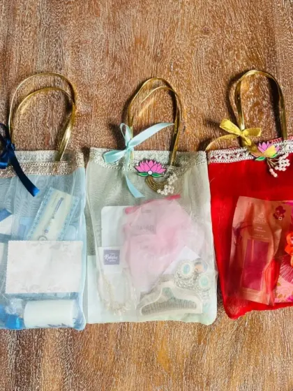 A trio of Rakhi gift bags in different colors: blue, mint, and red. These net bags are a great option for smaller, individual Rakhi gifts.
