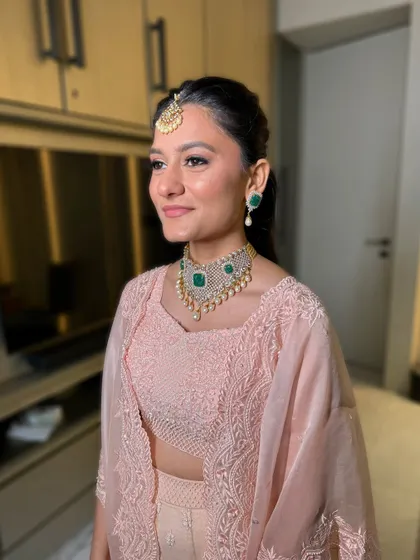 A side profile showing off her glowing skin and the elegant ponytail that lets her outfit and jewelry shine.