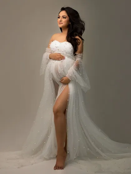 A beautiful profile shot of an expecting mother, looking towards the future. The details of the pearl-studded gown are captured perfectly in the studio light.