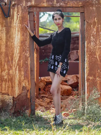 Framing the subject within a doorway of a rustic structure adds a strong compositional element to this outdoor portrait.