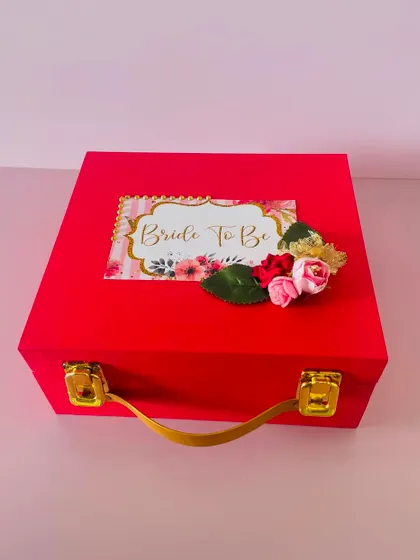 The outside of the "Bride to be" hamper, featuring a beautiful custom tag. This red suitcase box is perfect for celebrating the special milestone.