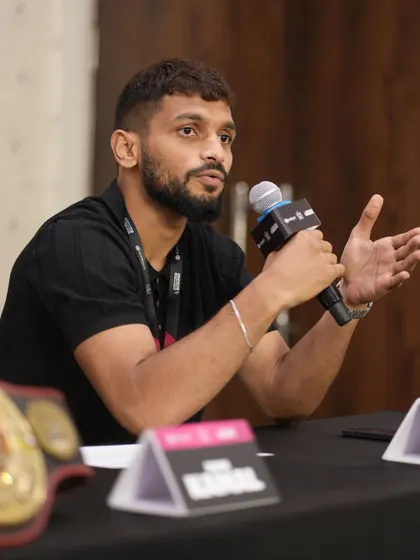 A fighter speaks passionately at a press conference, sharing his journey and confidence.