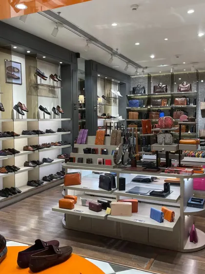 An overview of the product displays, showing a wide variety of leather goods including shoes, wallets, and bags.