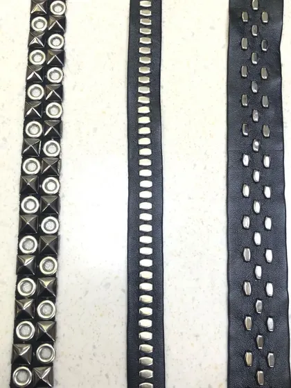 Three styles of modern studded laces on a black leather-like base. These trims are perfect for adding detail to jackets, trousers, or accessories for a contemporary, edgy look.