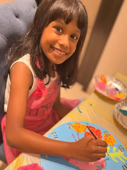 A young artist focused on adding the finishing touches to her flamingo clock at a birthday paint party. I provide pre sketched canvases so kids can focus on the joy of painting.