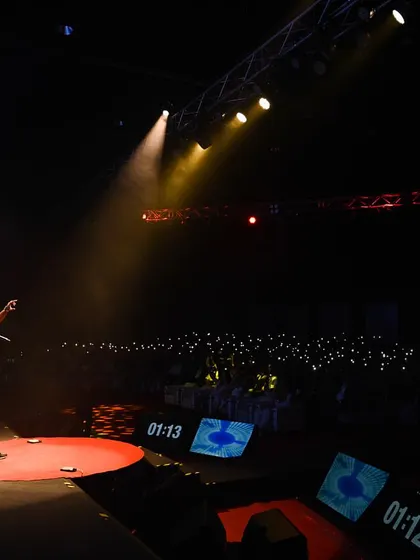 I perform from the red circle at TEDx Hyderabad, facing a dark auditorium dotted with the audience's lights.