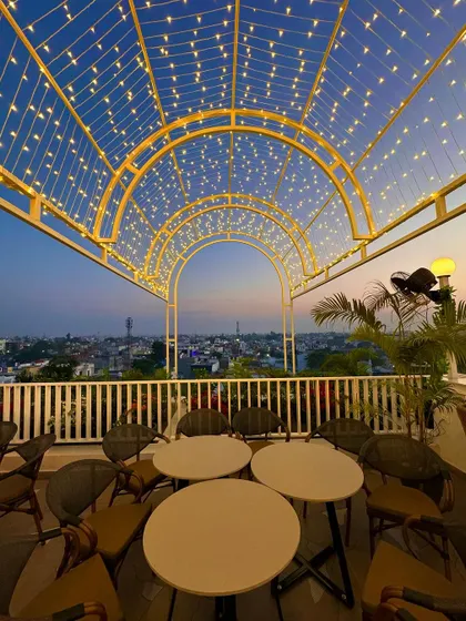 A view from one of the arched seating areas at Tipsy Town, looking out over Ayodhya. The fairy light canopy creates a starry sky effect, making the space feel like a home in the city.