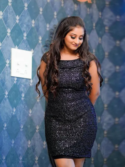 A candid moment from the same shoot. The lighting highlights the shimmer in the dress and the flawless finish of the makeup.