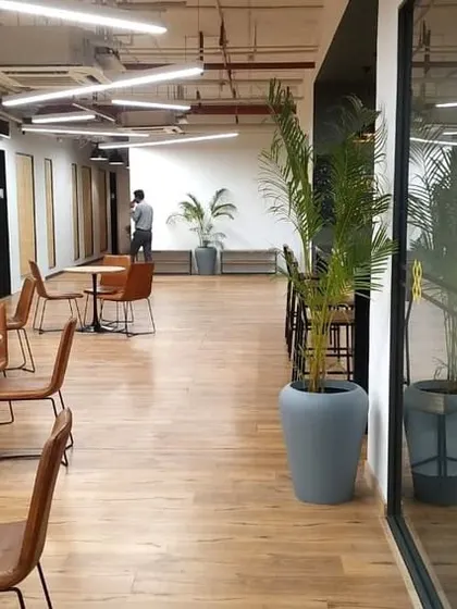 A shot of the informal seating area at VentureX, adjacent to a glass-walled office with the brand's logo. This demonstrates how we create fluid transitions between collaborative and private zones.