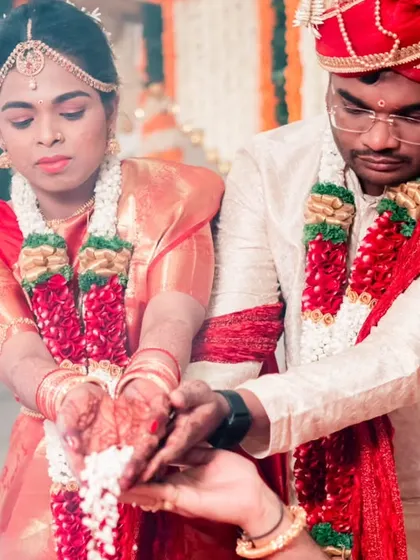 The couple performing rituals together, their hands joined as they receive blessings, showcasing their partnership.